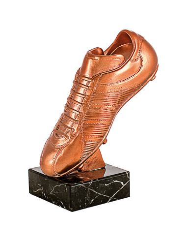 Trofeo de fútbol en forma de bota recubierta de cuero con tacos de resina metalizada y base de mármol negro.