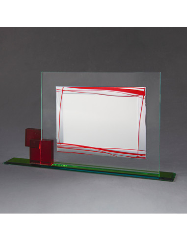 Placa de homenaje con base de vidrio y la placa en aluminio plateado con detalle decorativo en rojo. La grabación debe ser en t