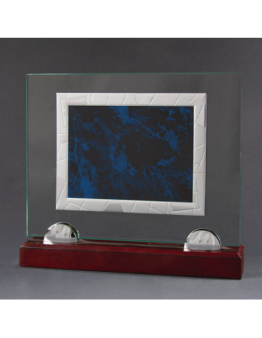 Placa de homenaje con base de vidrio y la placa en aluminio plateada y azul. La grabación debe ser con láser. Se puede complemen